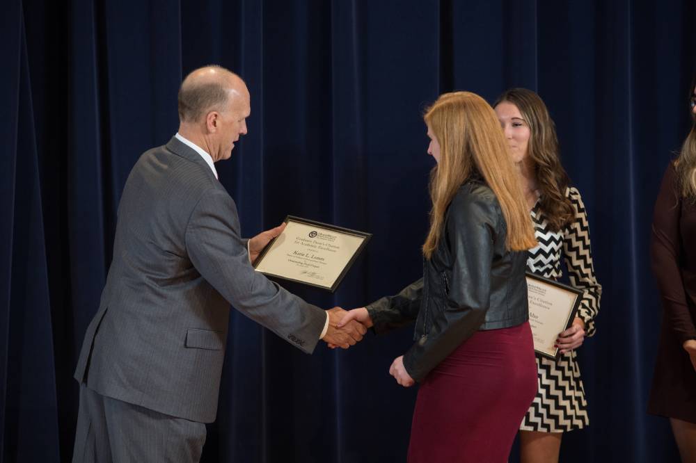 Student receiving an award from Dean Potteiger, shaking hands